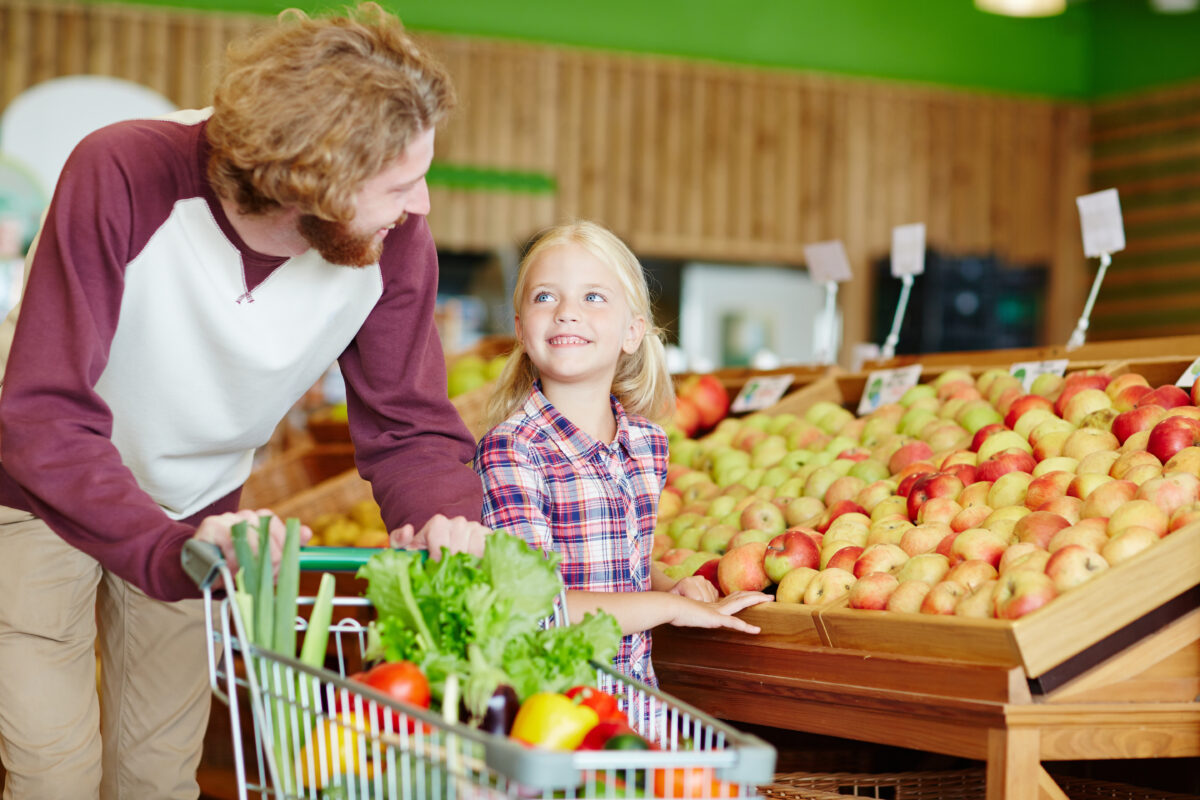 Buyers in supermarket Vater und Tochter beim Einkaufen im Supermarkt. Lebensmittel unverpackt.